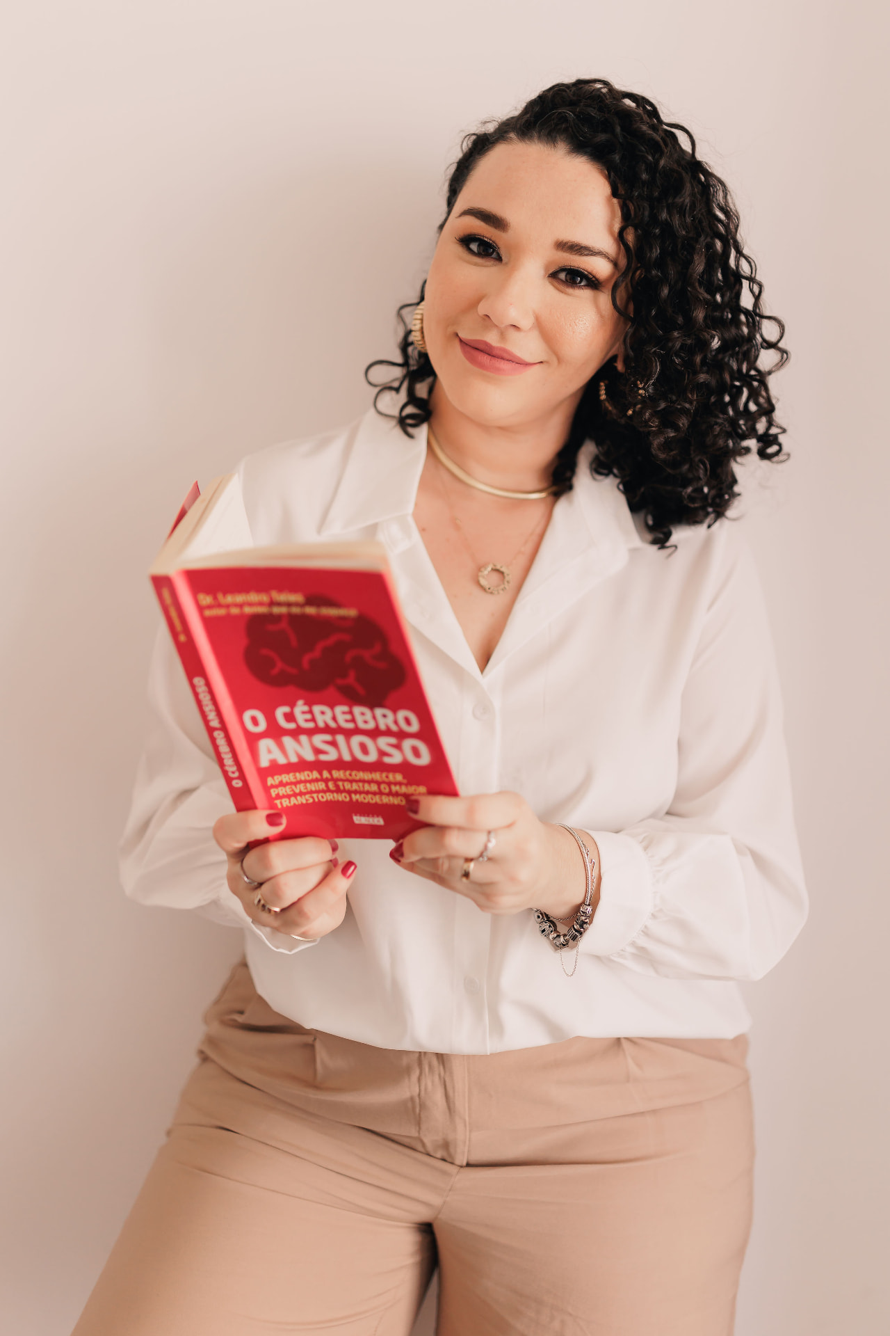 Retrato da psicóloga Denise Anjos segurando um livro